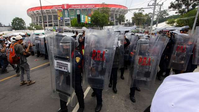 Riot police deploy tear gas to disperse protesters outside the stadium