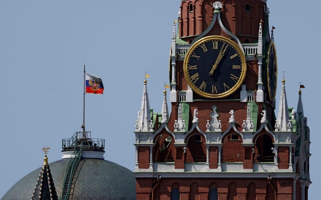 The Russian flag flying high above the historic Kremlin complex in Moscow.