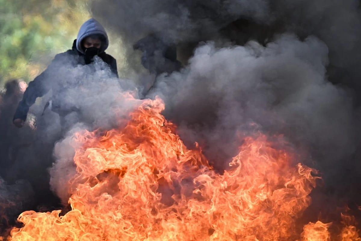 A protestor near a burning barricade during student demonstrations outside a secondary school in Aubervilliers, northern Paris, on October 1, 2026.