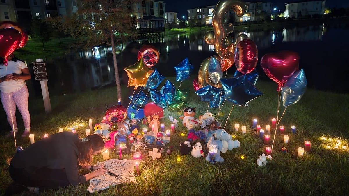 A somber scene depicting the area around a pond where two young brothers were tragically found after leaving their apartment.