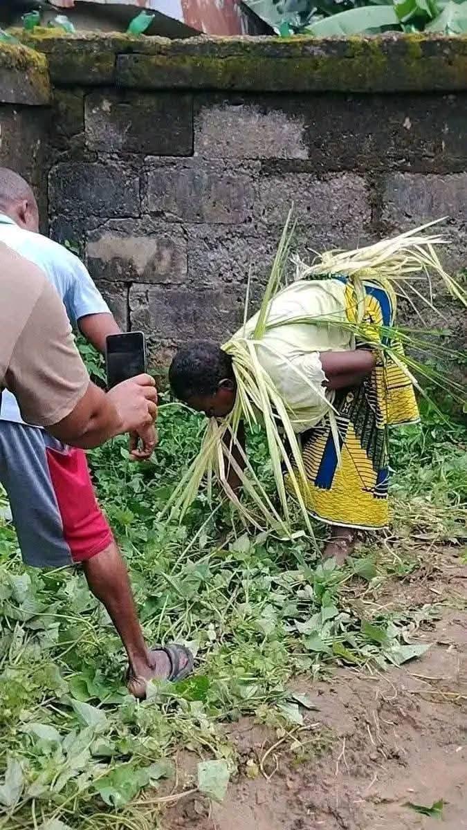 The elderly woman being paraded by villagers with palm fronds tied around her head in Amanfu, Enugu State.