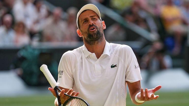 Novak Djokovic focused on the court during a Wimbledon match, possibly showing signs of fatigue.