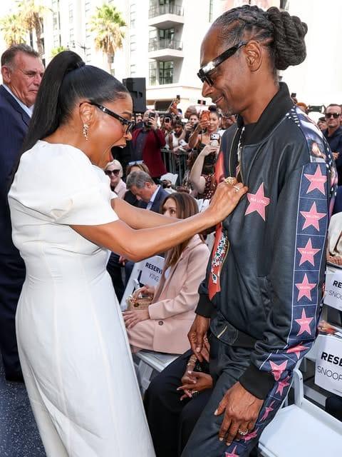 Nia Long expressing joy and surprise at Snoop Dogg's custom jacket tribute.