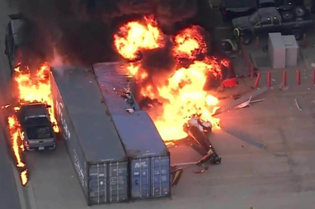 Firefighters battle flames engulfing the crashed NBC4 helicopter amidst the debris and emergency vehicles.