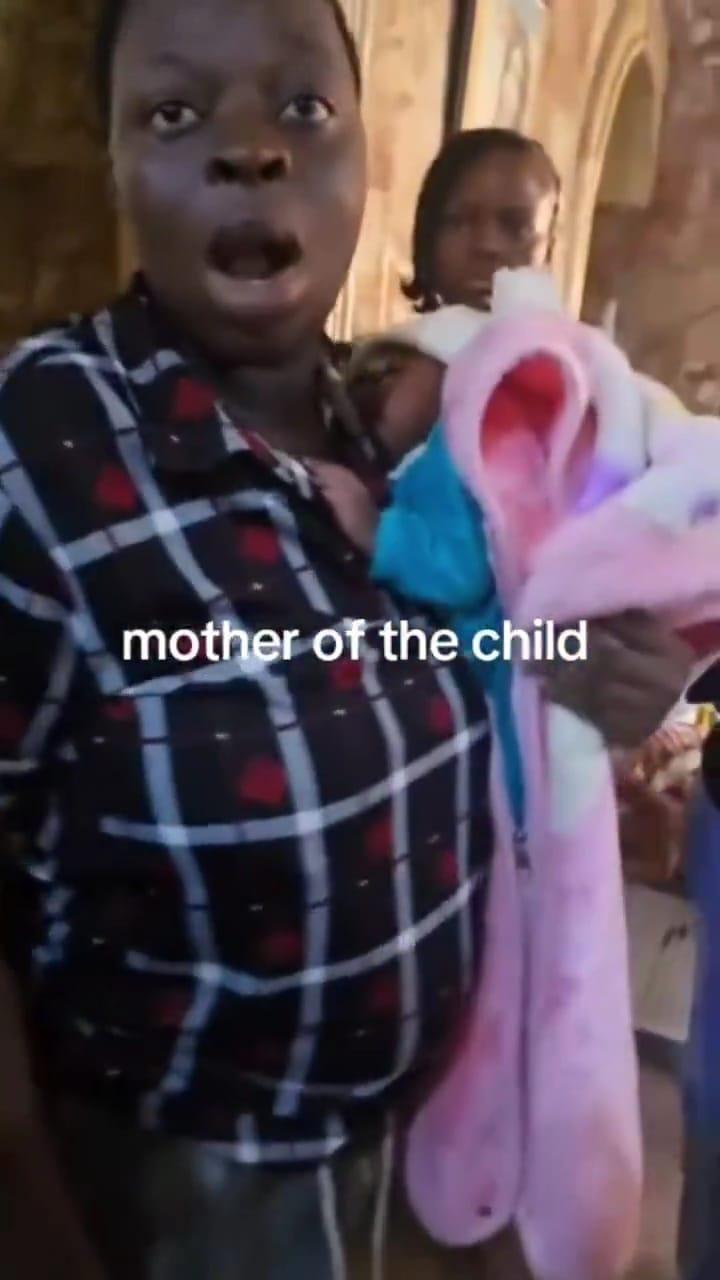 A doctor and hospital staff surrounding the woman accused of trying to kidnap a baby in Onitsha.