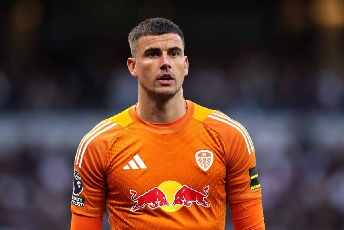 Karl Darlow, wearing his distinctive orange goalkeeper's kit, makes a save for Leeds United.