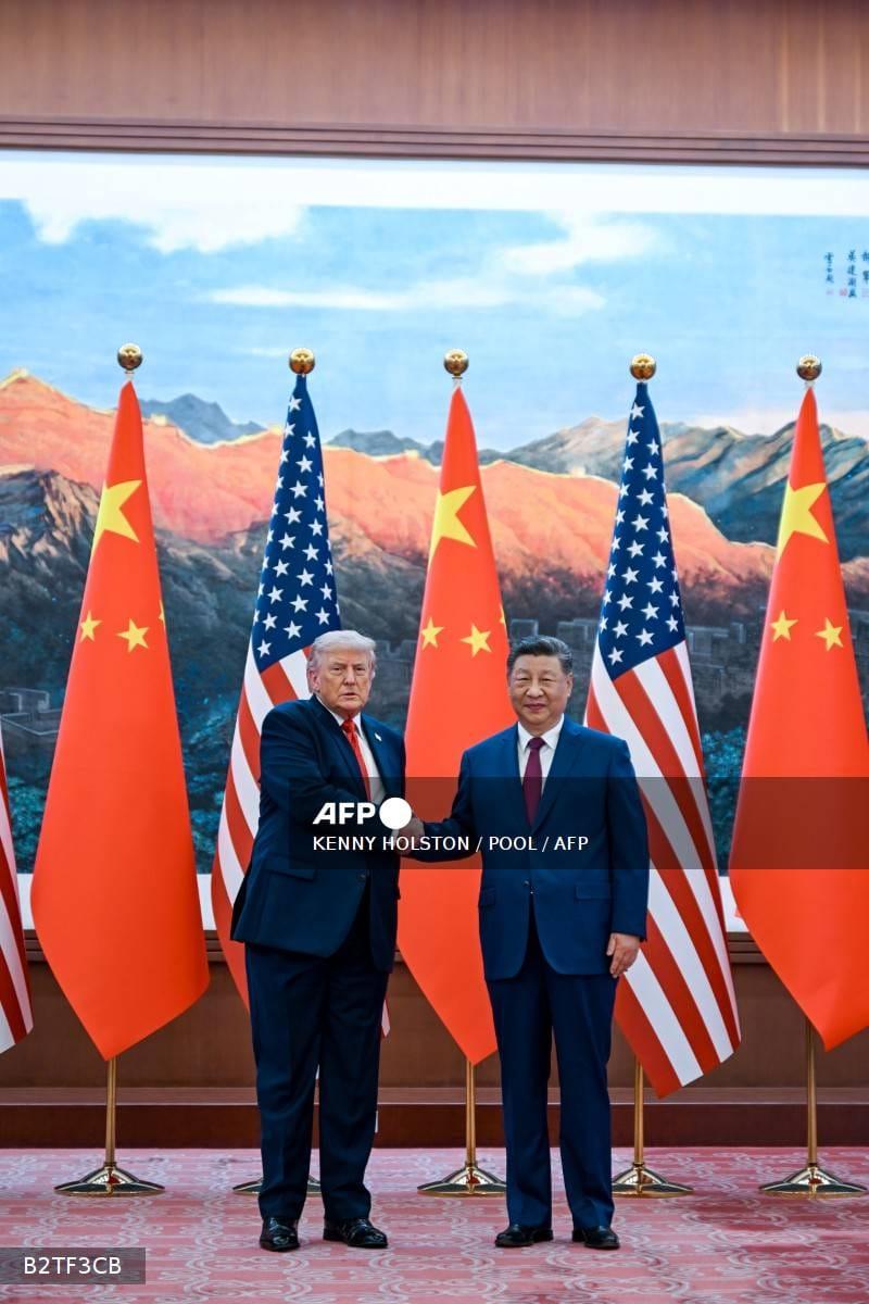 US President Donald Trump shaking hands with Chinese President Xi Jinping during a past meeting in Beijing, highlighting the complex diplomatic relationship between the two nations.