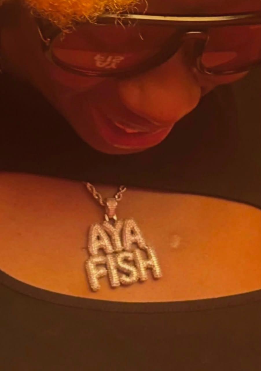 Gbemi posing with the custom neckpiece that has stirred social media reactions.
