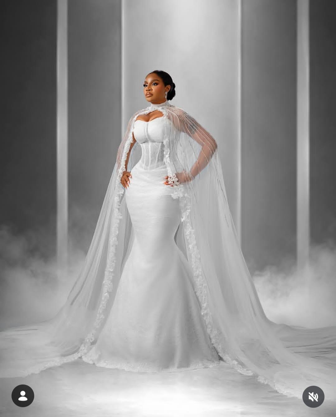 A thoughtful Uche Ogbodo in a stunning white wedding dress.
