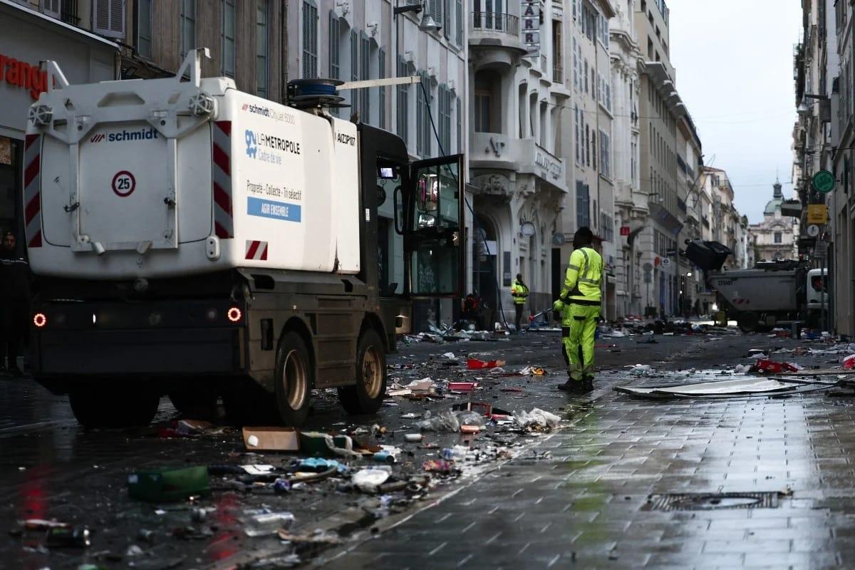 Cleaning crews clear debris from a street in Marseille on October 18, 2026, after extensive nationwide protests.