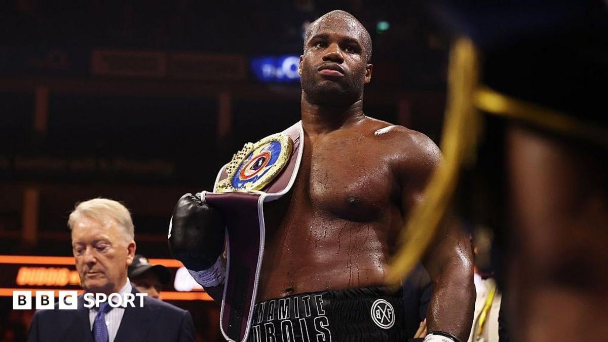 Daniel Dubois with his WBO heavyweight title belt on his shoulder, standing beside promoter Frank Warren.