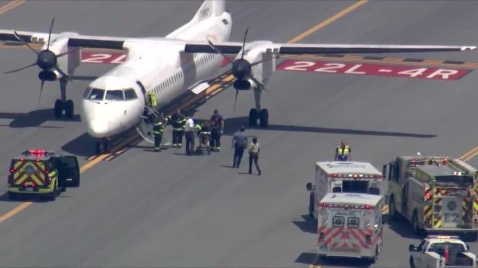 Ground crew and emergency vehicles gathered around the Air Canada twin-turboprop plane after its unscheduled landing in Boston.