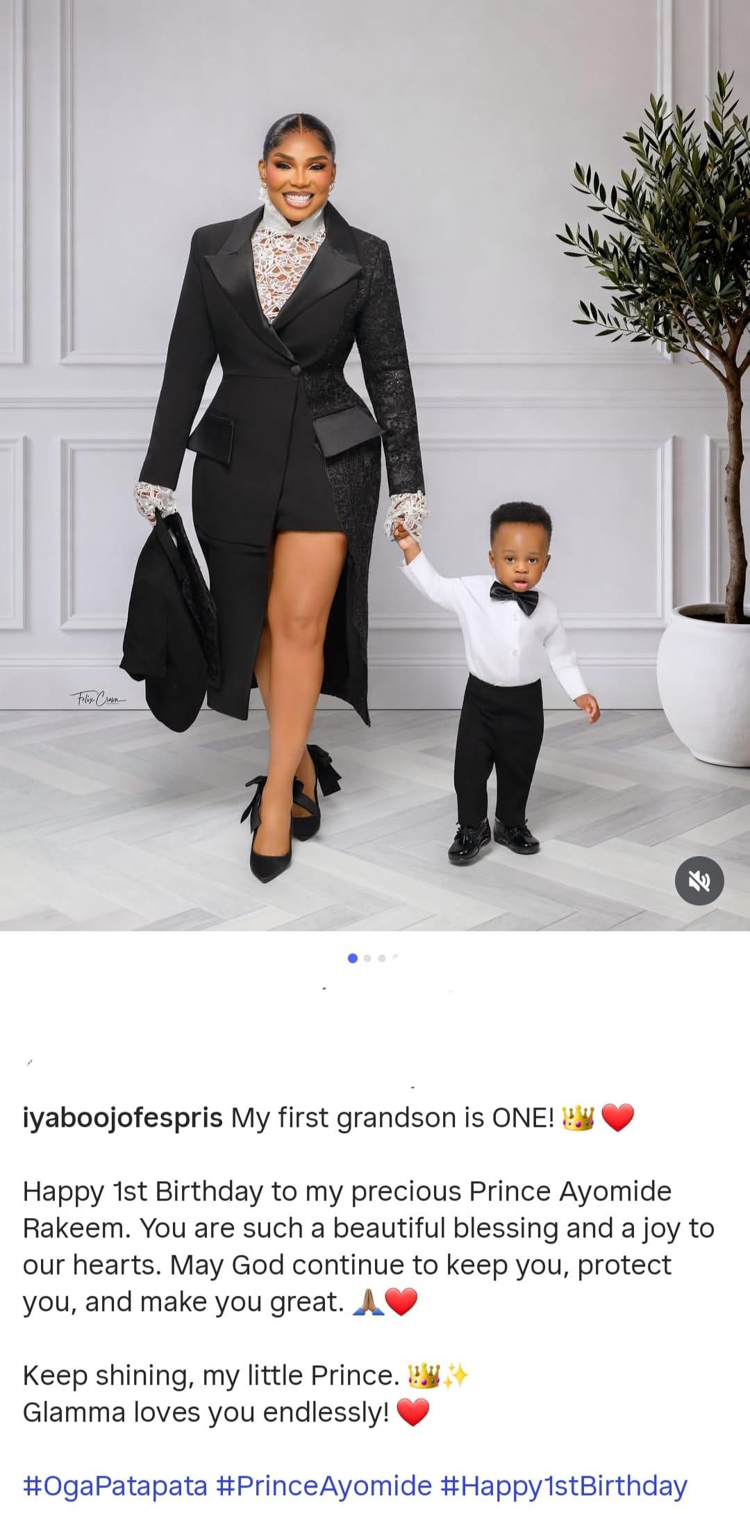 Iyabo Ojo affectionately holding her grandson Rakeem, both dressed in matching formal wear.