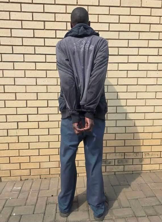 The arrested suspect, James Mohajane, in police custody after being handed over by community members.
