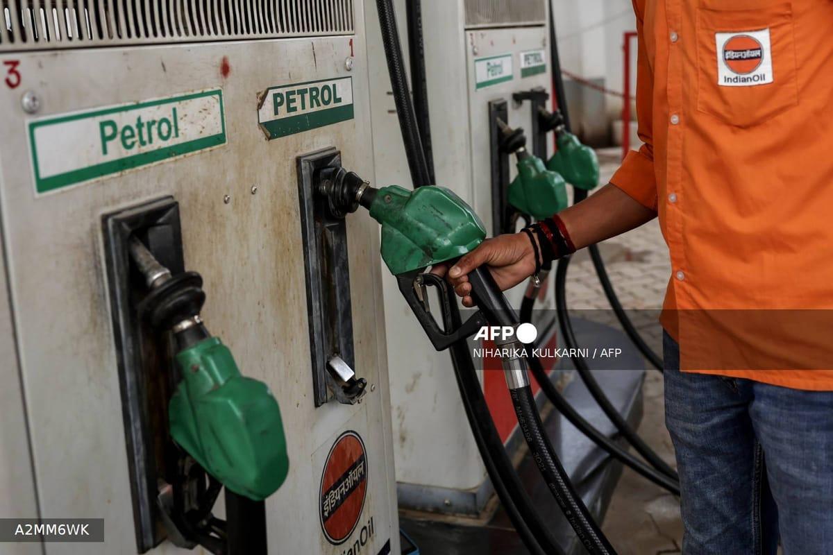 A petrol pump attendant refuels a vehicle at a fuel station, illustrating the ongoing demand for petroleum products despite rising costs.
