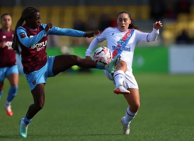 Viviane Asseyi and Jamie-Lee Napier competing for the ball during a football match.