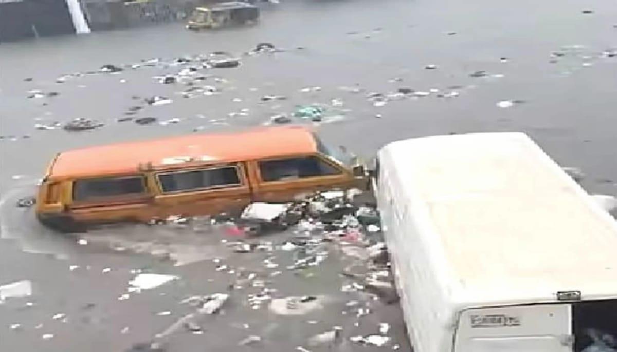 A commercial bus and a delivery van stuck in deep floodwaters on a road in Lagos.