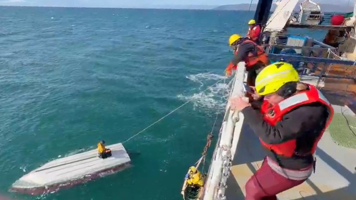 Rescue crew approaching the overturned boat where the 15-year-old survivor was found.