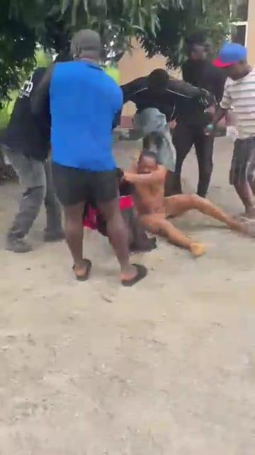 Students gathered around a man who is being physically attacked by the mob.