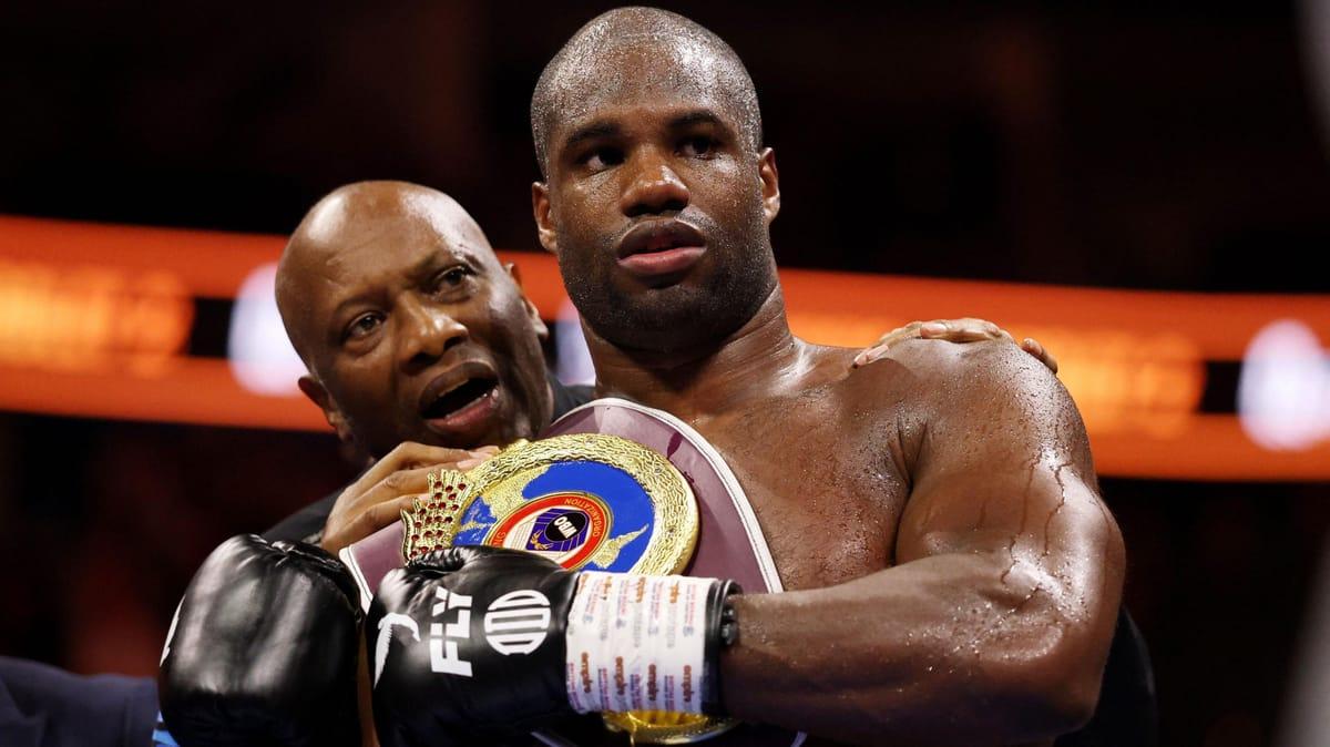 Daniel Dubois proudly displaying his WBO heavyweight title belt after his victory.