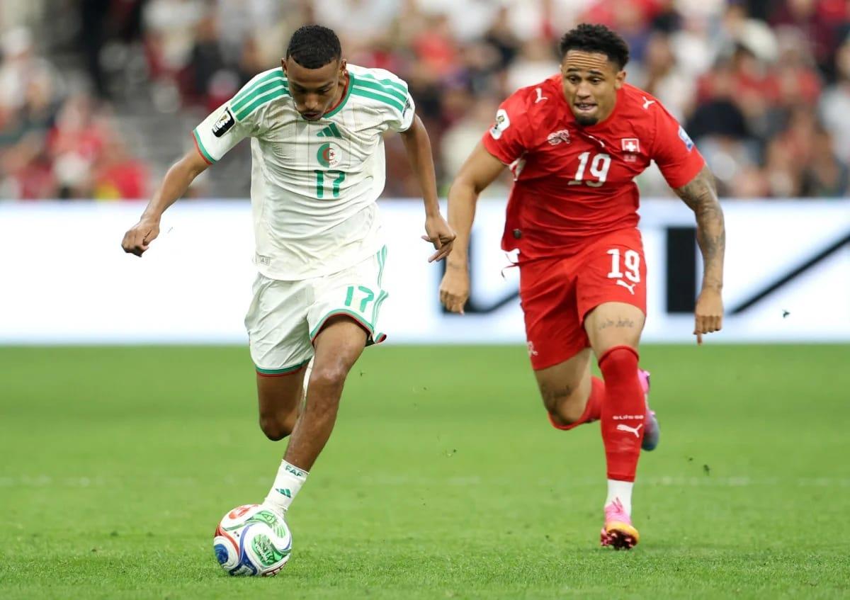 Algeria's Rafik Belghali #17 under pressure from Switzerland's Noah Okafor #19 during their FIFA World Cup 2026 Round of 32 encounter in Vancouver.