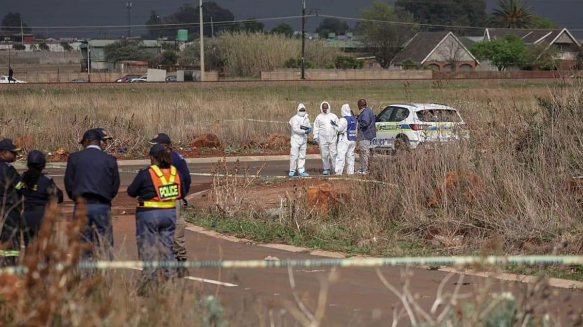Forensic personnel investigating a crime scene where a woman's body was discovered.
