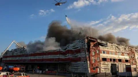 Reuters A firefighting helicopter drops water over the site of a Russian missile strike, amid Russia's attack on Ukraine, in Kyiv region, 19 July 2026