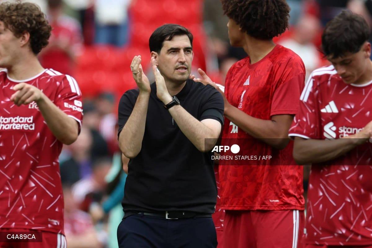 Andoni Iraola, head coach of Liverpool, interacts with players and fans during a pre-season friendly match against Monaco at Anfield.