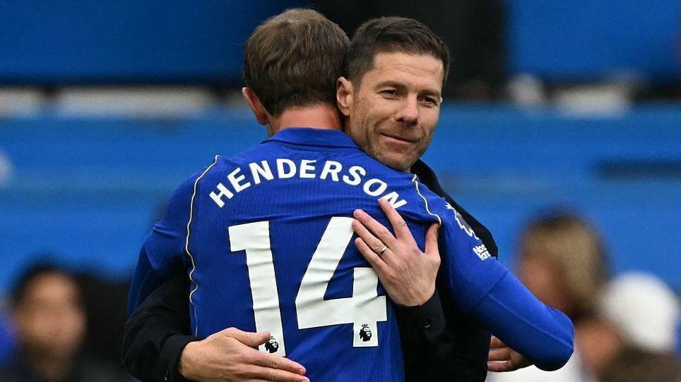Jordan Henderson and Xabi Alonso sharing a moment during a football game.
