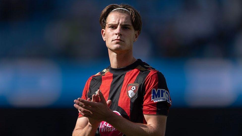 Alex Scott of Bournemouth applauding fans after a match.